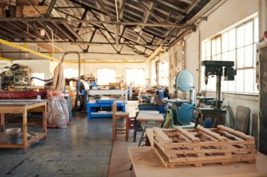 Interior of a large carpentry workshop full of workbenches and a variety of tools and other machinery