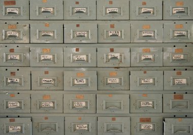 Large metal cabinet of drawers filled with an assortment of small parts inside of a woodworking shop