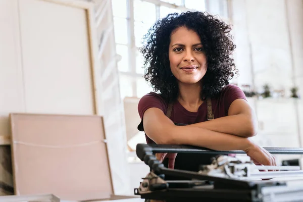 Portrait Young Woman Smiling While Leaning Mat Cutter Table Her — Stockfoto