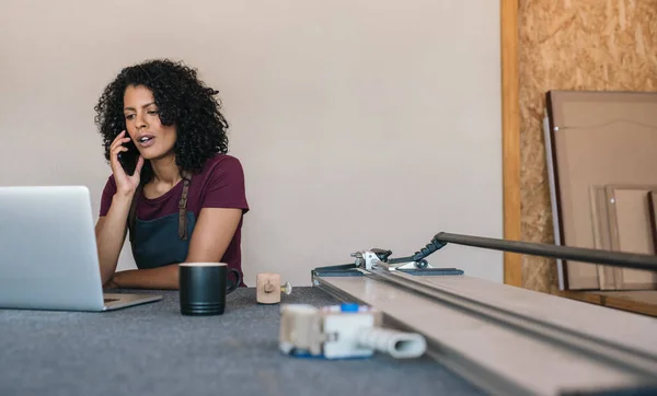 Junge Kunsthandwerkerin Arbeitet Einem Laptop Und Telefoniert Mit Einem Kunden — Stockfoto