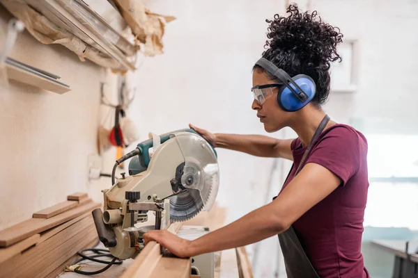 Junge Kunsthandwerkerin Schneidet Ihrer Bilderrahmenwerkstatt Mit Der Gehrungssäge Holzteile — Stockfoto