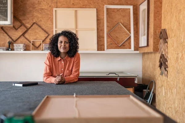 Retrato Uma Jovem Sorridente Com Cabelo Encaracolado Sentado Uma Mesa — Fotografia de Stock