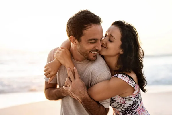 愛情のある若い女性抱擁彼女の夫と楽しいです一緒に砂浜で夕日 — ストック写真