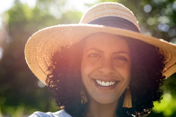 一个阳光灿烂的夏日下午 一个微笑的年轻女子站在公园外面 戴着太阳帽的画像 — 图库照片