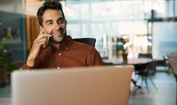 Üzletember Mosolyog Beszél Mobilján Miközben Egy Laptopon Dolgozik Asztalánál Egy — Stock Fotó