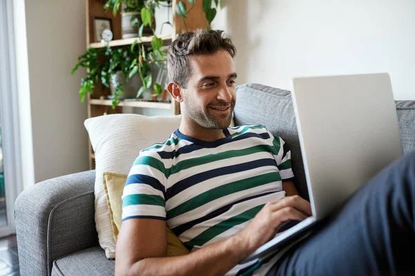 Jovem Sorridente Navegando Line Laptop Enquanto Sentado Seu Sofá Sala — Fotografia de Stock