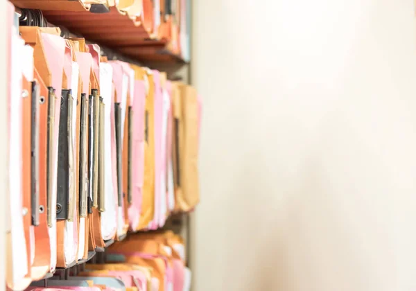 Traditional filing cabinets filled with files of several colors