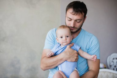 Onun tatlı bebek tutan genç mutlu adam portresi