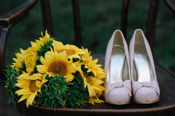 Hermosos zapatos de boda con tacones altos y un ramo de girasoles —  Fotos de Stock