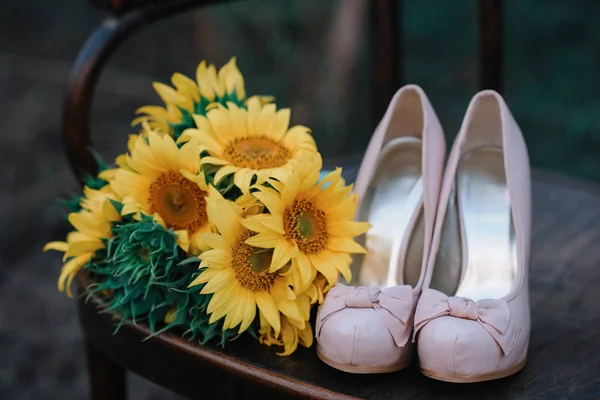 Όμορφη γαμήλια παπούτσια με ψηλά τακούνια και ένα μπουκέτο από ηλιοτρόπια — Φωτογραφία Αρχείου