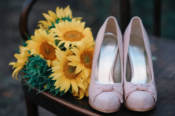 Hermosos zapatos de boda con tacones altos y un ramo de girasoles —  Fotos de Stock