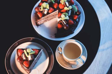 Tişört ve siyah arka plan üzerine taze meyve fincan çikolatalı kek parçasıyla