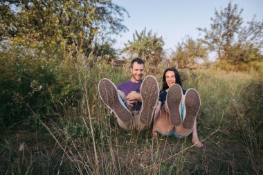 Genç mutlu couplesitting çim ile onların köpek - yorkshire korkunç 