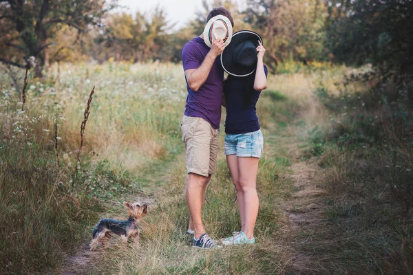 젊은 커플 강아지와 함께 요크 셔 테리어와 t-셔츠와 모자 수용 입고도 재미가 — 스톡 사진