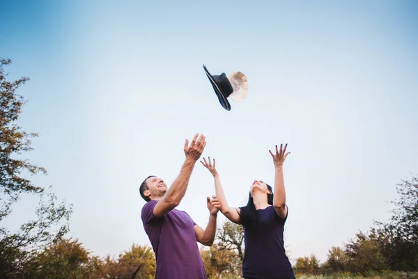 若いカップルが帽子を空中に投げ — ストック写真