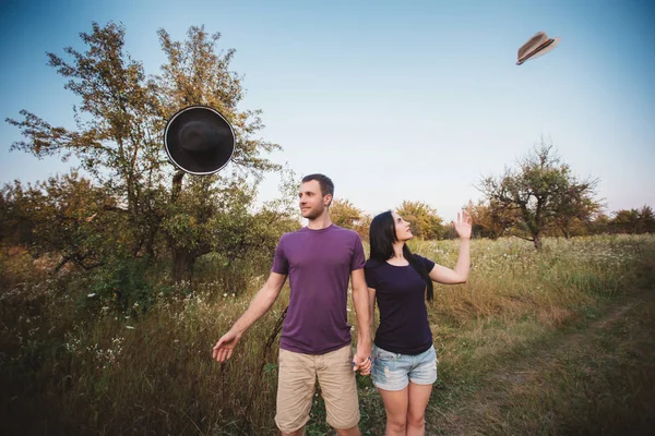 若いカップルが帽子を空中に投げ — ストック写真