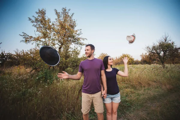 Молода пара кидає капелюхи в повітря — стокове фото