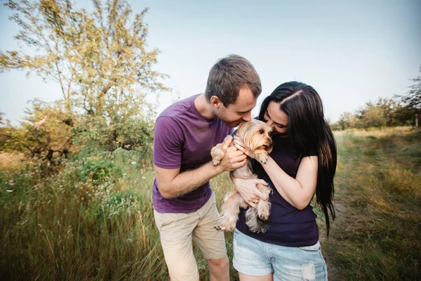 Молода щаслива пара позує зі своєю собакою — стокове фото
