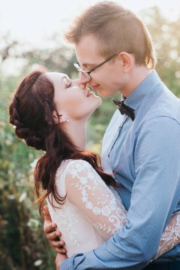 Mutlu gelin ve damat açık doğa yerde gün batımında güneş portresi