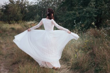 Bankanın doğa üzerinde beyaz bir elbise içinde iplik Yong gelin