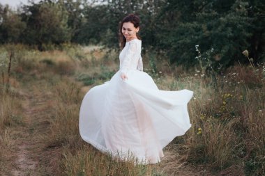 Bankanın doğa üzerinde beyaz bir elbise içinde iplik Yong gelin