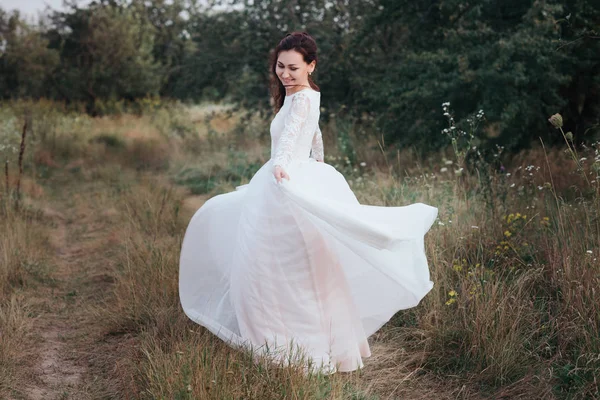 Yong menyasszony spinning egy fehér ruha, a bank a természet — Stock Fotó