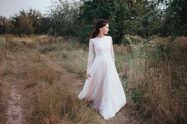 Yong mariée filant dans une robe blanche sur la rive sur la nature — Photo