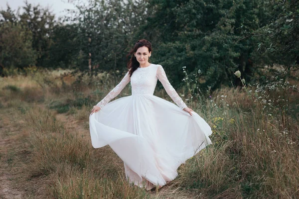 Молодая красивая невеста с прической и макияжем в белом платье — стоковое фото