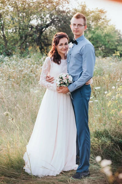 Acabo de casarme amante pareja hipster en vestido de novia y traje en un campo verde en el bosque. —  Fotos de Stock