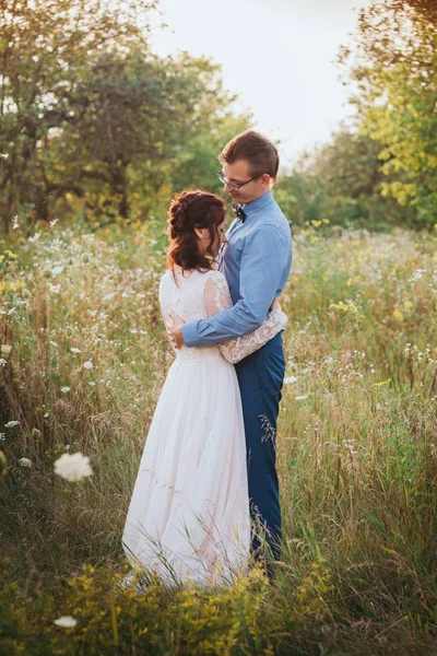 Acabo de casarme amante pareja hipster en vestido de novia y traje en un campo verde en el bosque. —  Fotos de Stock