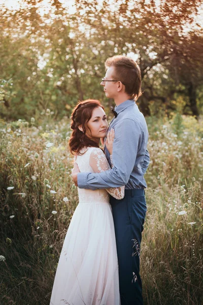 Acabo de casarme amante pareja hipster en vestido de novia y traje en un campo verde en el bosque. —  Fotos de Stock