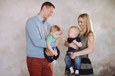 Baba ve anne ile iki küçük oğlu oynuyor. İki küçük çocuk çocuklar, kardeşler İkizler ve veliler eğleniyor