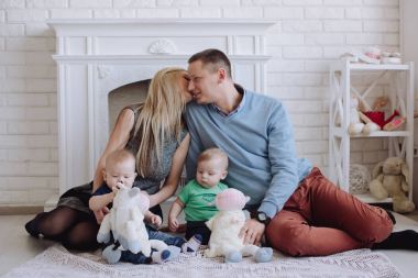 Baba ve anne ile iki küçük oğlu oynuyor. İki küçük çocuk çocuklar, kardeşler İkizler ve veliler eğleniyor