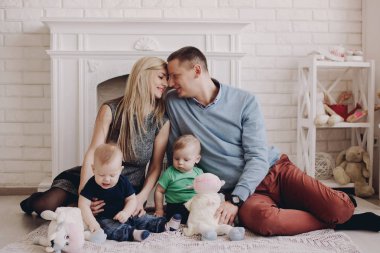 Baba ve anne ile iki küçük oğlu oynuyor. İki küçük çocuk çocuklar, kardeşler İkizler ve veliler eğleniyor