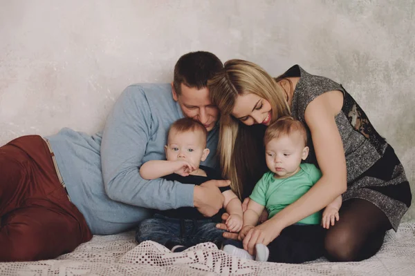 Vater und Mutter spielen mit zwei kleinen Söhnen. Zwei kleine Jungen, Geschwister Zwillinge und Eltern haben Spaß — Stockfoto