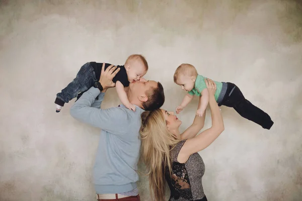 Vater und Mutter spielen mit zwei kleinen Söhnen. Zwei kleine Jungen, Geschwister Zwillinge und Eltern haben Spaß — Stockfoto