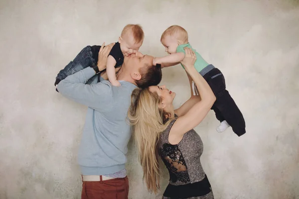 Vater und Mutter spielen mit zwei kleinen Söhnen. Zwei kleine Jungen, Geschwister Zwillinge und Eltern haben Spaß — Stockfoto