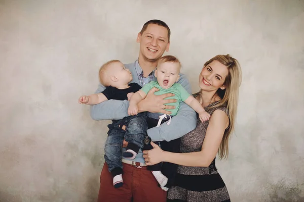 Glückliches Familienporträt. Eltern mit Baby zwei Jungen Zwillinge. — Stockfoto