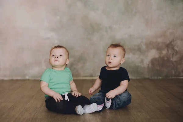 Two brother twins sitting. Two little kid boys watching at camera. — Stock Photo, Image