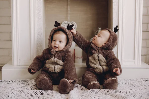 Two twin babies boys. They are setting together in a deer costumes. — Stock Photo, Image