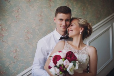 Evlilik çift niteliğine birbirlerine sarılıyor. Beyaz elbiseli güzel model kız. Takım elbiseli adam. Güzellik gelinle damat.