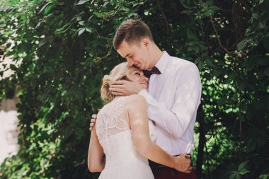 Evlilik çift niteliğine birbirlerine sarılıyor. Beyaz elbiseli güzel model kız. Takım elbiseli adam. Güzellik gelinle damat.