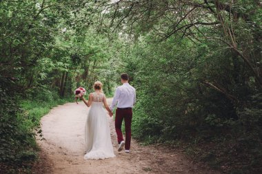 Genç güzel evlilik çift kamera için geri bir alanda sarılma.