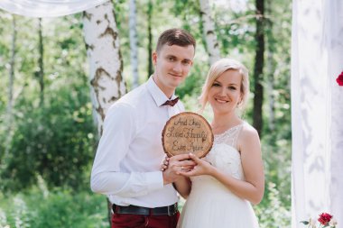 Evlilik çift niteliğine birbirlerine sarılıyor. Beyaz elbiseli güzel model kız. Takım elbiseli adam. Güzellik gelinle damat.