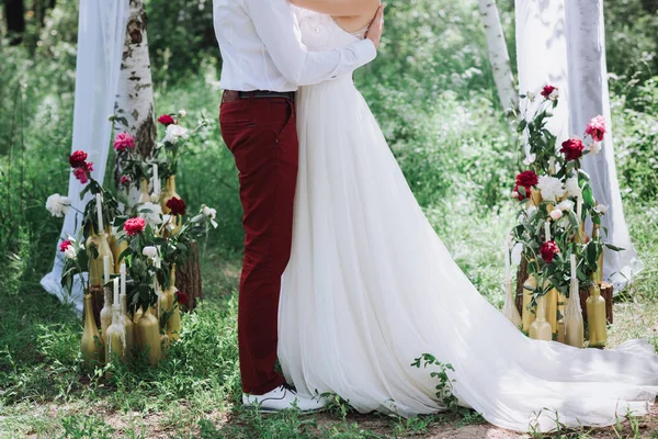 Giovane bella coppia, sposa e sposo nella foresta. Sullo sfondo della decorazione di nozze . — Foto Stock