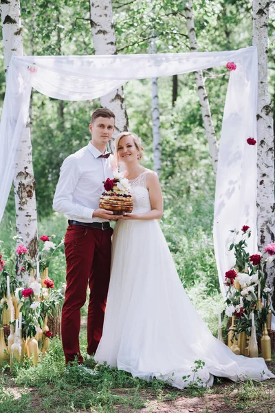 Jeune beau couple, mariée et marié dans la forêt. Dans le contexte du décor de mariage . — Photo