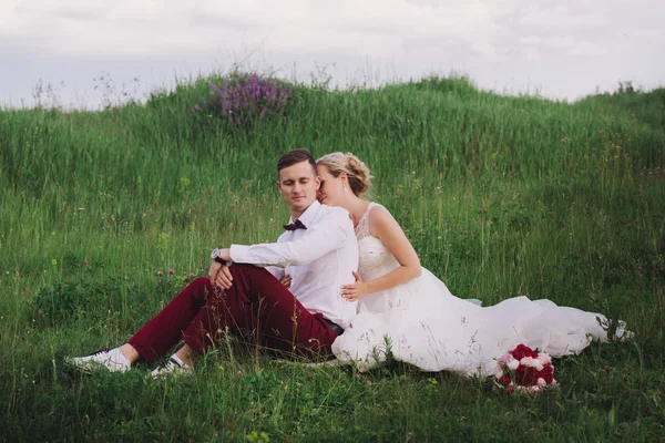 Mladé krásné svatební pár objímání na přírodu. Krásný pár, nevěsta a ženich pózuje — Stock fotografie