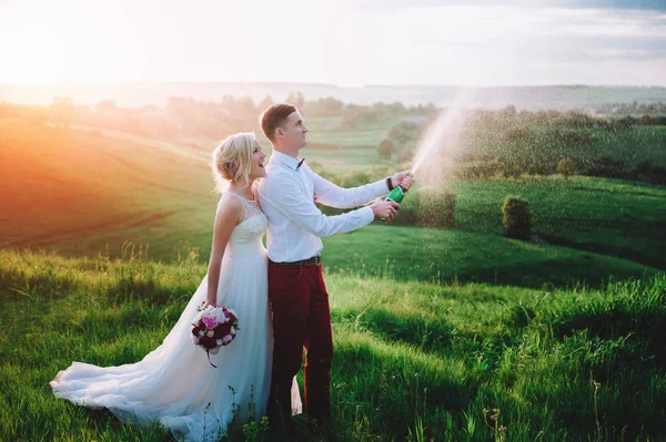 Champaine ve şampanya sıçramalarına buttle ile mutlu evlilik çift — Stok fotoğraf