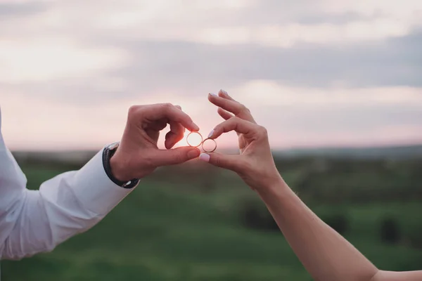 Руки в коханні - Обручка з людською рукою на заході сонця — стокове фото