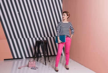 Eller şık kadın ona bir dizüstü bilgisayar ile çizgili tişört ve pembe pantolon, yaşam tarzı, blogger, iş, online alışveriş